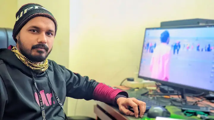 A developer at his desk with code open on the monitor